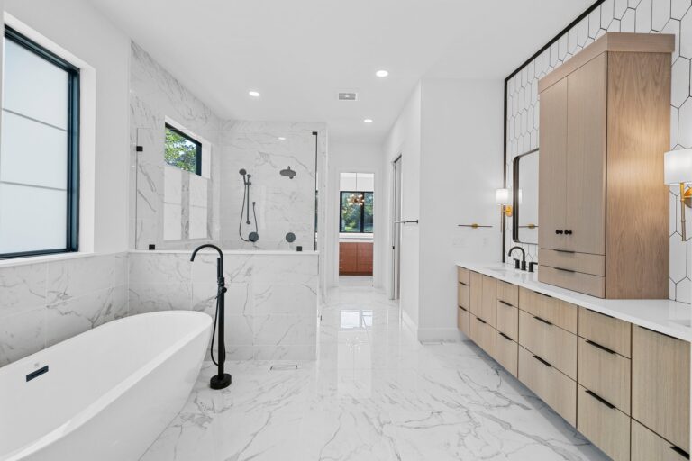 This is a master bath remodel with custom tile shower, matte black hardward, bench, niche, freestanding tub and custom white oak double vanity in Fenton, Missouri